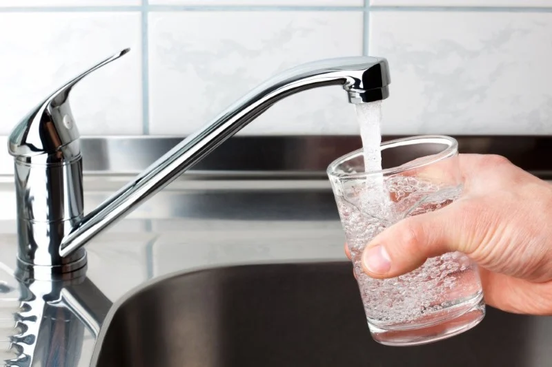 Glass of water being filled by a sink