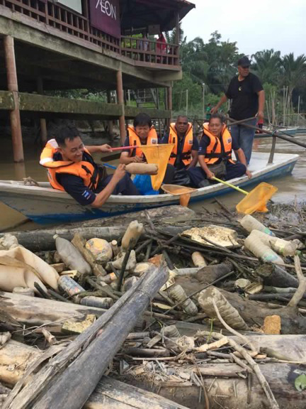 Malaysia-clean-up-team-fishing-plastic-bottles-from-the-water.jpg