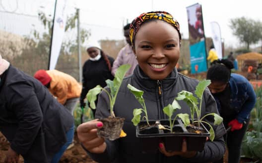 Girl holding sprout tray with plants in it