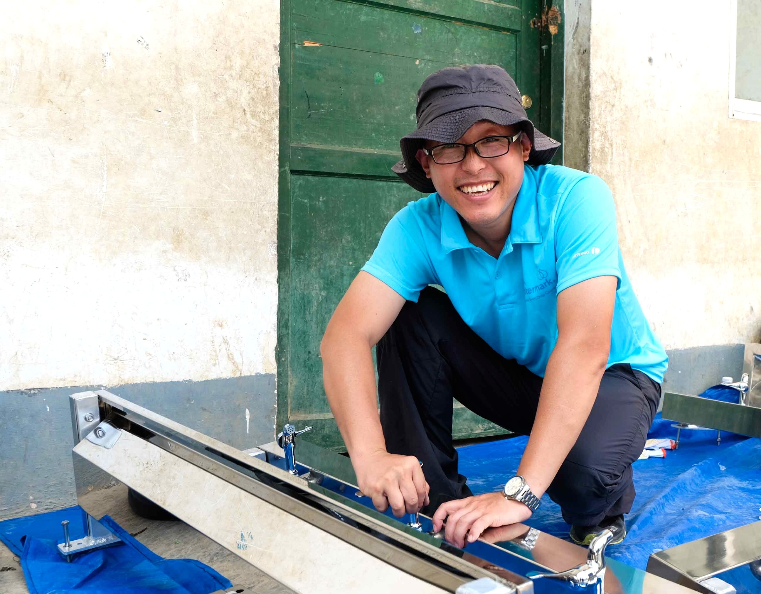 A male volunteer crouching down and smiling